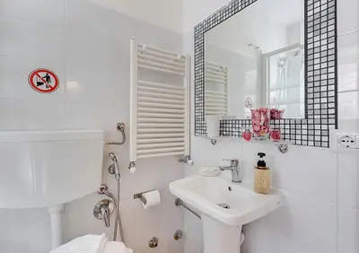 a white bathroom with a sink and a mirror at Machiavelli Suites in Rome