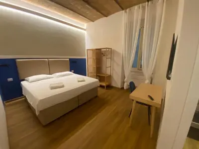 a bedroom with a white bed and a wooden floor at Eutierra BLeisure Stay in Rome
