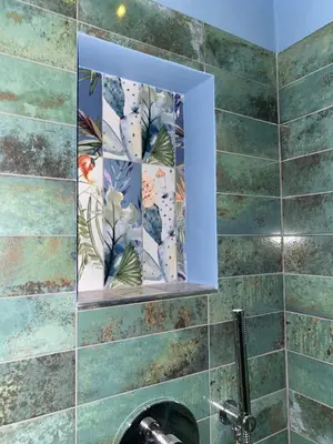 a bathroom with a mirror on a tiled wall at Eutierra BLeisure Stay in Rome