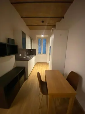 a kitchen with a wooden table and chairs in a room at Eutierra BLeisure Stay in Rome
