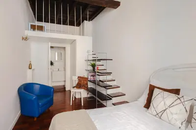 a bedroom with a bed and a blue chair at Dadi Inn Monti in Rome