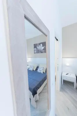 a mirror in a white room with a bed at Vantaggio Suites in Rome