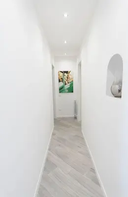 an empty hallway with white walls and a tile floor at Vantaggio Suites in Rome
