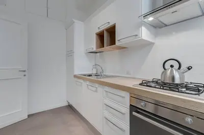 a white kitchen with a tea kettle on the counter at Vantaggio Suites in Rome