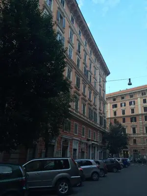 a row of cars parked in front of a large building at Vantaggio Suites in Rome