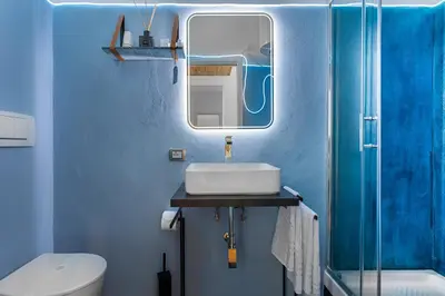 a blue bathroom with a sink and a toilet at LPR Pantheon - Stylish Apartment at the Pantheon in Rome