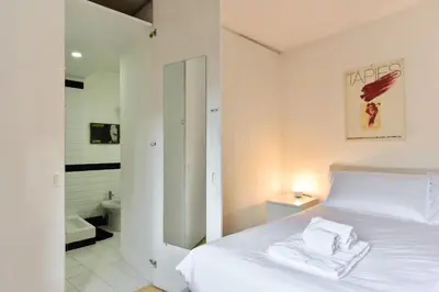 a bedroom with a white bed and a bathroom at Appartamento Piazza Navona in Rome