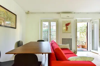 a dining room with a red couch and a table at Appartamento Piazza Navona in Rome
