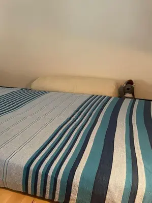 a bed with a striped comforter in a bedroom at Centro storico appartamento con terrazza in Rome