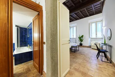 a room with a bathroom with a tub and a table at iFlat Magnificent flat near the Colosseum in Rome