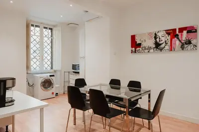 a dining room with a glass table and black chairs at Be Your Home - Mazzini 144 in Rome