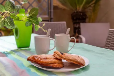 a plate with two pastries on a table with two cups at iFlat Wonderful Home in Monti in Rome