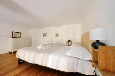 a bedroom with a large white bed with a lamp at Super appartamento nel cuore del Pigneto in Rome