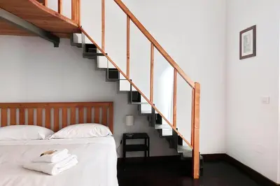 a bedroom with a bed and a staircase at Super appartamento nel cuore del Pigneto in Rome