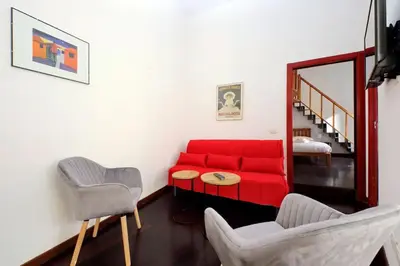 a living room with a red couch and two chairs at Super appartamento nel cuore del Pigneto in Rome