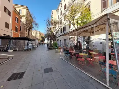 an empty street with tables and chairs on a sidewalk at Super appartamento nel cuore del Pigneto in Rome
