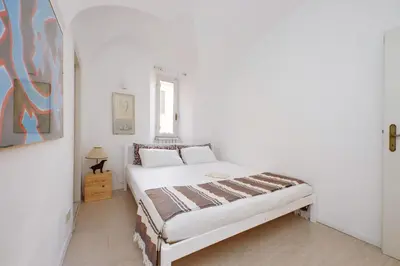 a bedroom with a bed in a white room at Cimarra Apartment in Rome