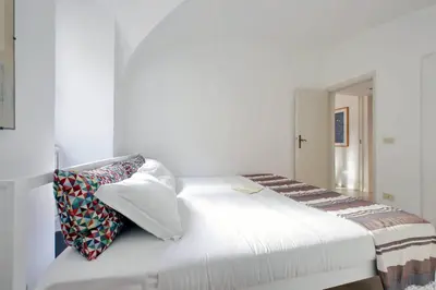a bedroom with a white bed with pillows on it at Cimarra Apartment in Rome