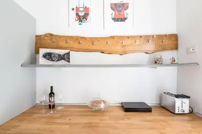 a shelf on a wall with wine glasses and a bottle at Casa Esquilina in Rome