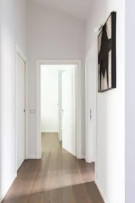 a hallway with white walls and white doors and wooden floors at Casa Esquilina in Rome