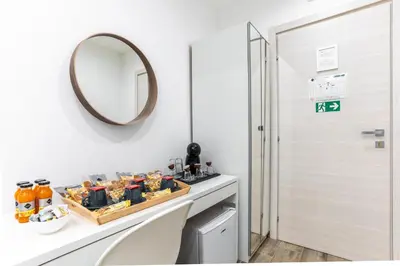 a white bathroom with a mirror and a sink at B&B Toto al Vaticano in Rome