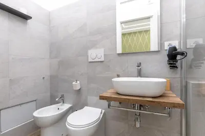 a bathroom with a sink and a toilet and a mirror at B&B Toto al Vaticano in Rome