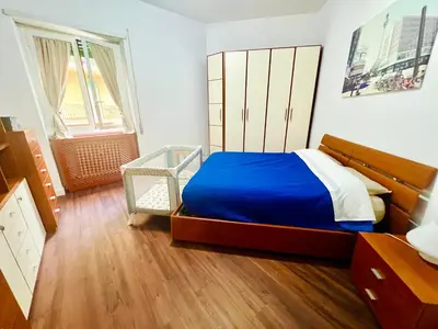 a bedroom with a bed with a blue blanket at Elegant Apartment Villa Bianca in Rome