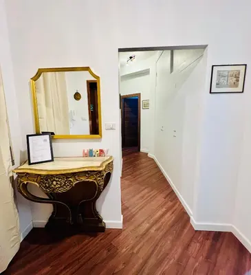 a hallway with a table and a mirror on the wall at Elegant Apartment Villa Bianca in Rome