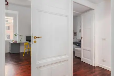 a white door in a room with a desk at Colosseum Home-ZENO 32 in Rome