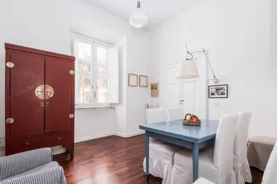 a dining room with a blue table and white chairs at Colosseum Home-ZENO 32 in Rome