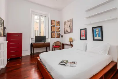 a bedroom with a large white bed and a desk at Colosseum Home-ZENO 32 in Rome