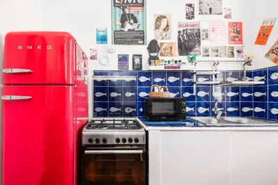 a kitchen with a red refrigerator and a stove at Colosseum Home-ZENO 32 in Rome