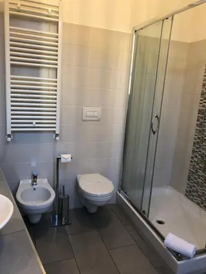 a bathroom with a toilet and a shower and a sink at San Vito Suites in Rome