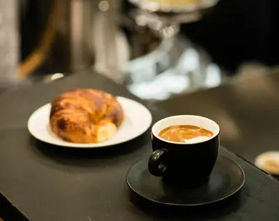 a cup of coffee and a pastry on a table at San Vito Suites in Rome
