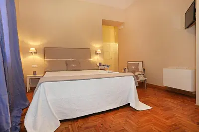 a bedroom with a large bed with a white blanket at San Vito Suites in Rome