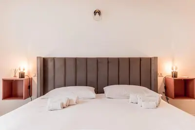 a large white bed with two towels on it at Vatican Central Residence in Rome