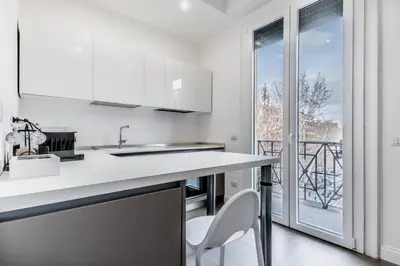 a white kitchen with a counter and a balcony at Vatican Central Residence in Rome