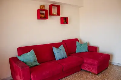 a red couch with blue pillows in a room at Luminoso non lontano dalla stazione TERMINI in Rome