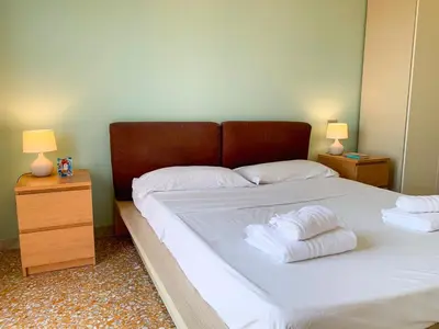 a bedroom with a bed with white sheets and towels at Luminoso non lontano dalla stazione TERMINI in Rome