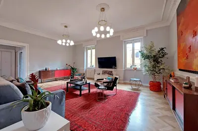 a living room with a blue couch and a red rug at LuxuryTerrace RomeApartment in Rome