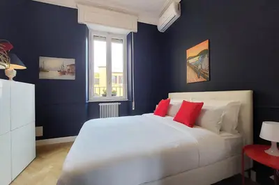 a bedroom with a large white bed with red pillows at LuxuryTerrace RomeApartment in Rome