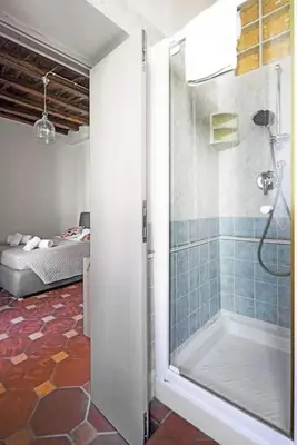 a bathroom with a shower and a bed in a room at Suite Valeria in Rome