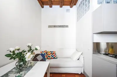 a white living room with a couch and a table at Suite Valeria in Rome