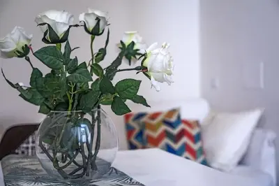 a vase filled with white flowers on a table at Suite Valeria in Rome