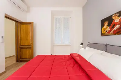 a bedroom with a red blanket on a bed at Atelier dello Statuto, a few steps from Colosseo in Rome