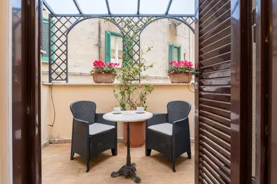 a table and chairs on a balcony with a window at Atelier dello Statuto, a few steps from Colosseo in Rome