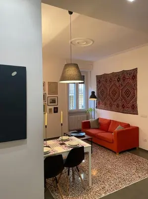a living room with a red couch and a table at Cozy apartment near the Colosseum in Rome