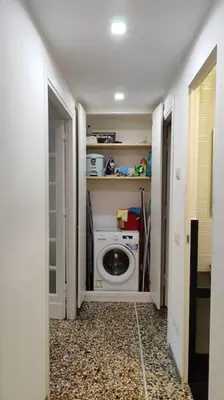 a laundry room with a washing machine in a hallway at Cozy apartment near the Colosseum in Rome