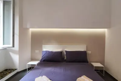 a bedroom with a bed with purple sheets and pillows at Cozy apartment near the Colosseum in Rome