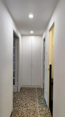 a hallway with white doors and a tile floor at Cozy apartment near the Colosseum in Rome